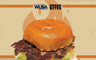 A hamburger with a toasted bun and leafy greens is displayed against a beige background with a flame graphic, evoking the essence of BBQ. Logos for "WSA" and "Smash Bites" are at the top.