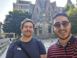 Nick and Arya taking a selfie and smiling, while standing in front of some historic buildings. 